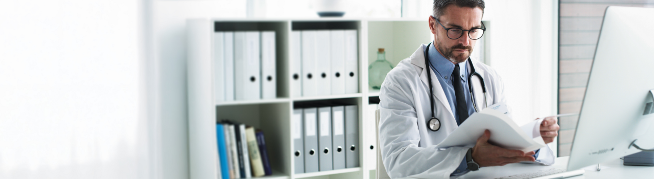 Cardiologist in lab coat reviews printed research at desk, emphasizing evidence supporting catheter ablation treatment.