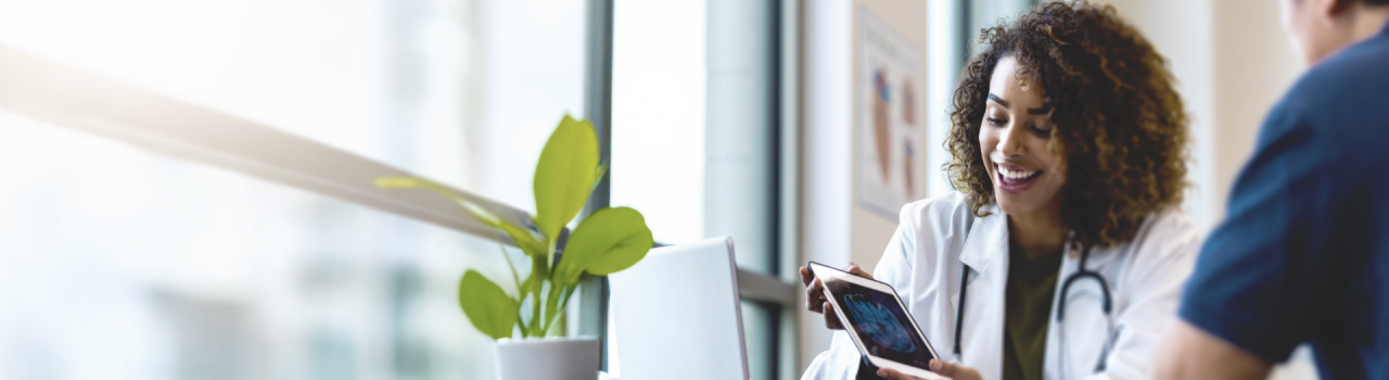 Female doctor in lab coat shows a tablet to a patient, introducing Boston Scientific's FARAPULSE™ PFA system.