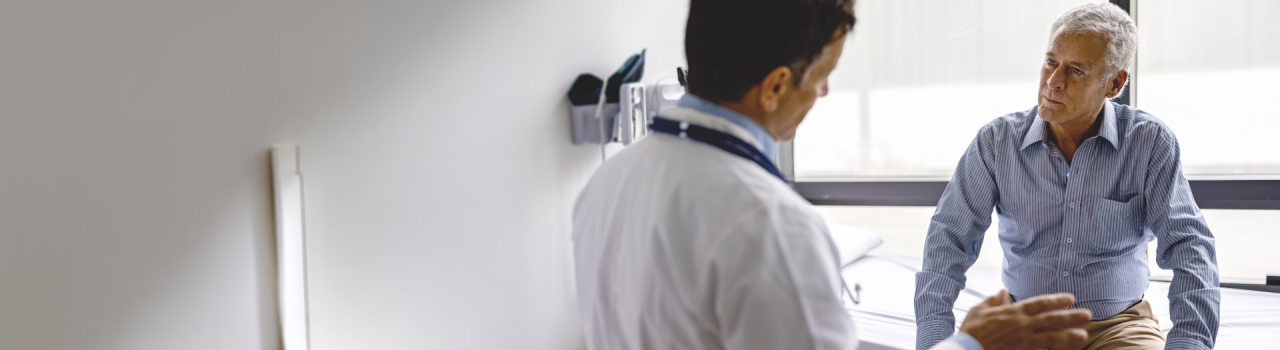 Male doctor talks to older patient with white hair, sharing Boston Scientific’s answers on atrial fibrillation.